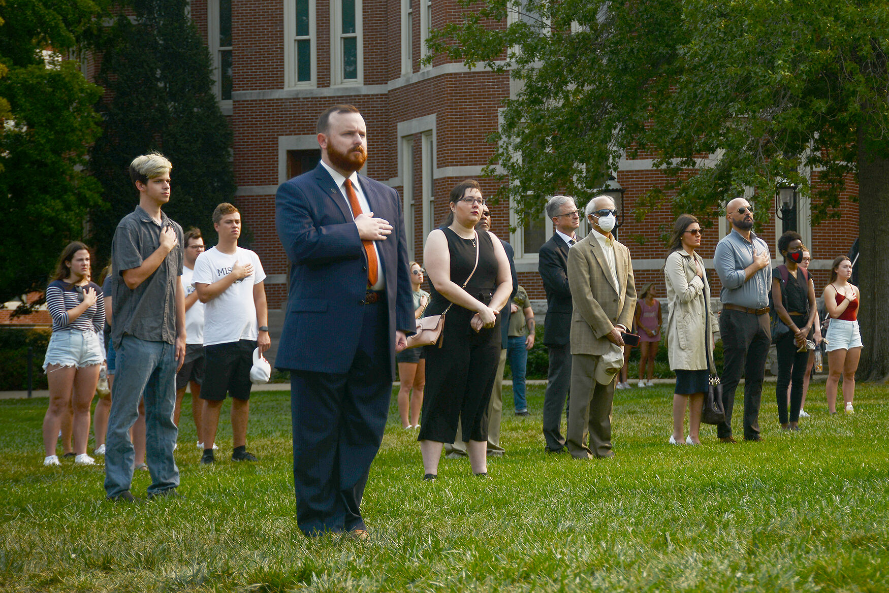People place their hands over their heart as the band plays the national anthem
